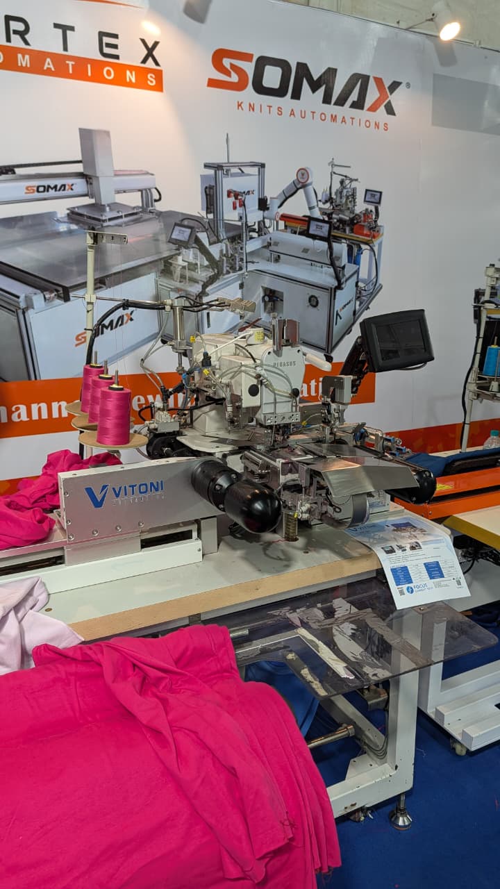 Automated sewing machine and robotic garment-handling systems on display at the Somax Knits Automations stall, Knit Show 2026.